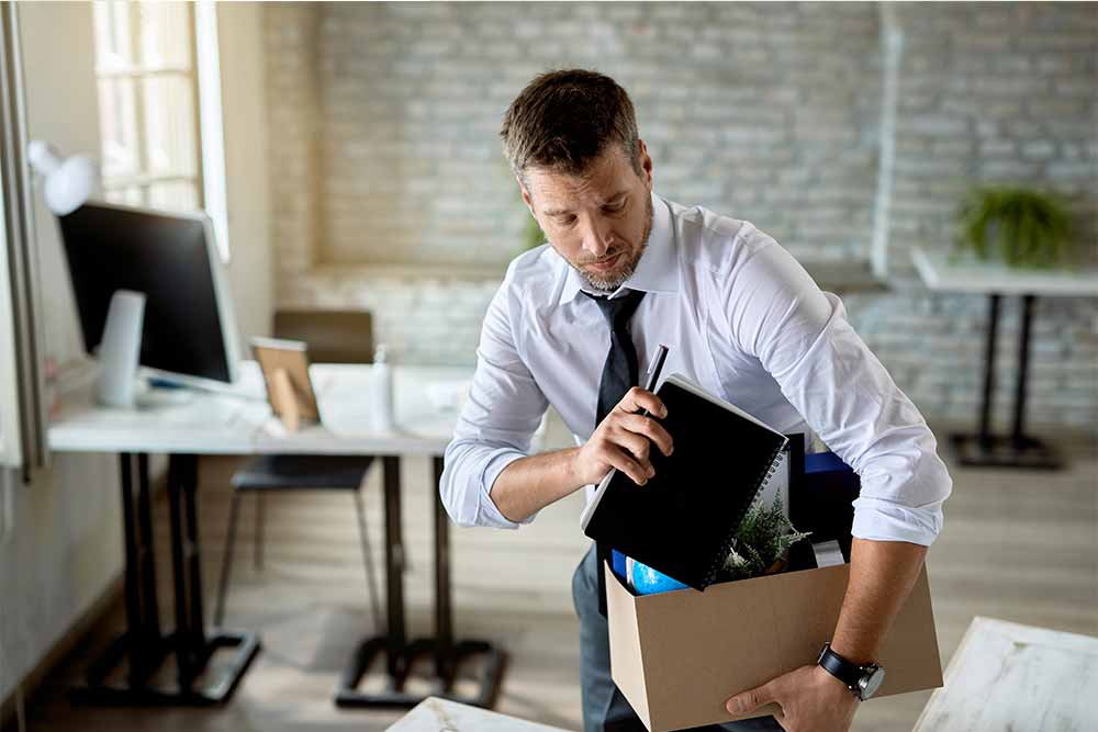 Lavoratore che raccoglie le sue cose dopo dimissioni dal contratto a termine